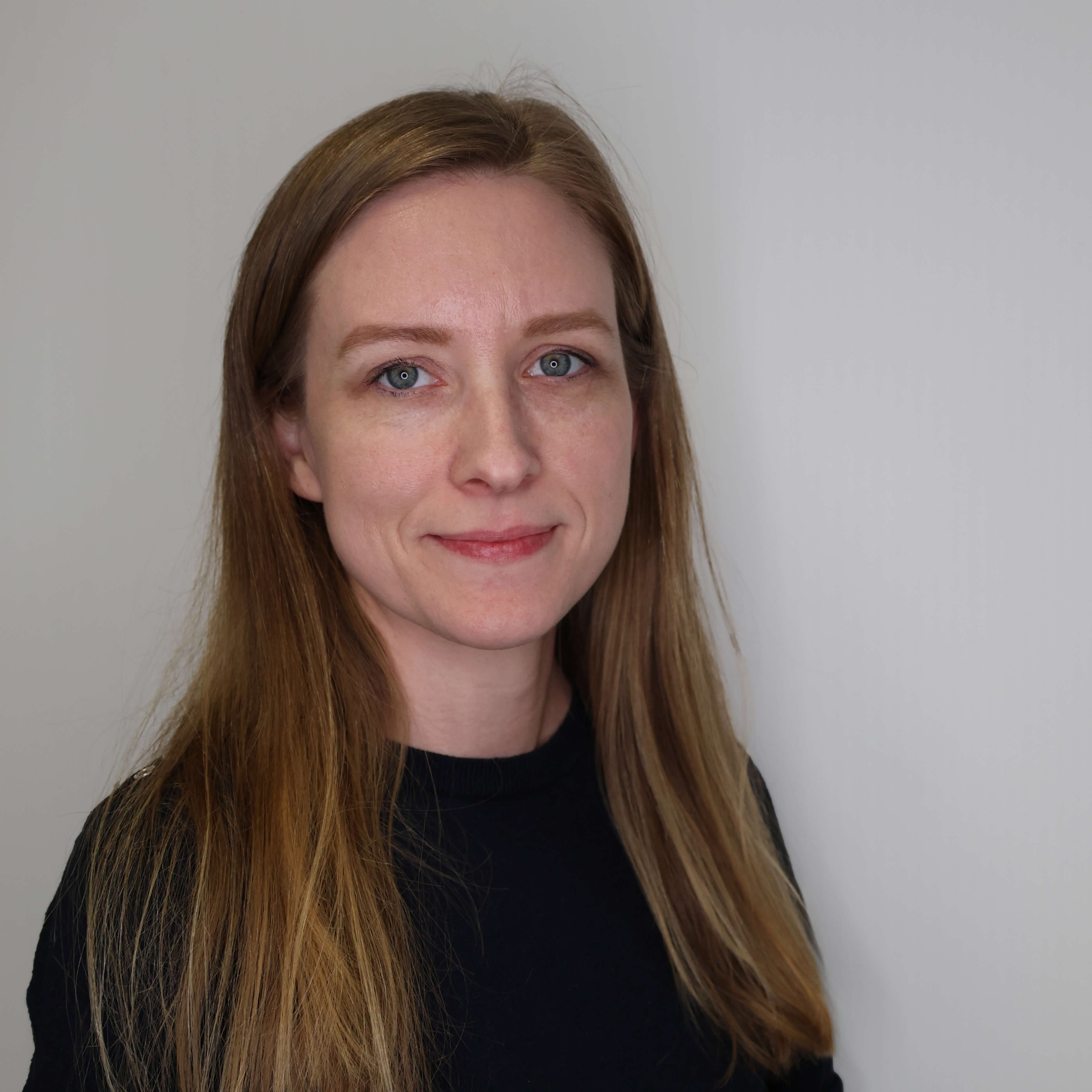 Anita Holzer filialleiterin-in-einem-schwarzen-shirt-vor-einer-grauen-wand