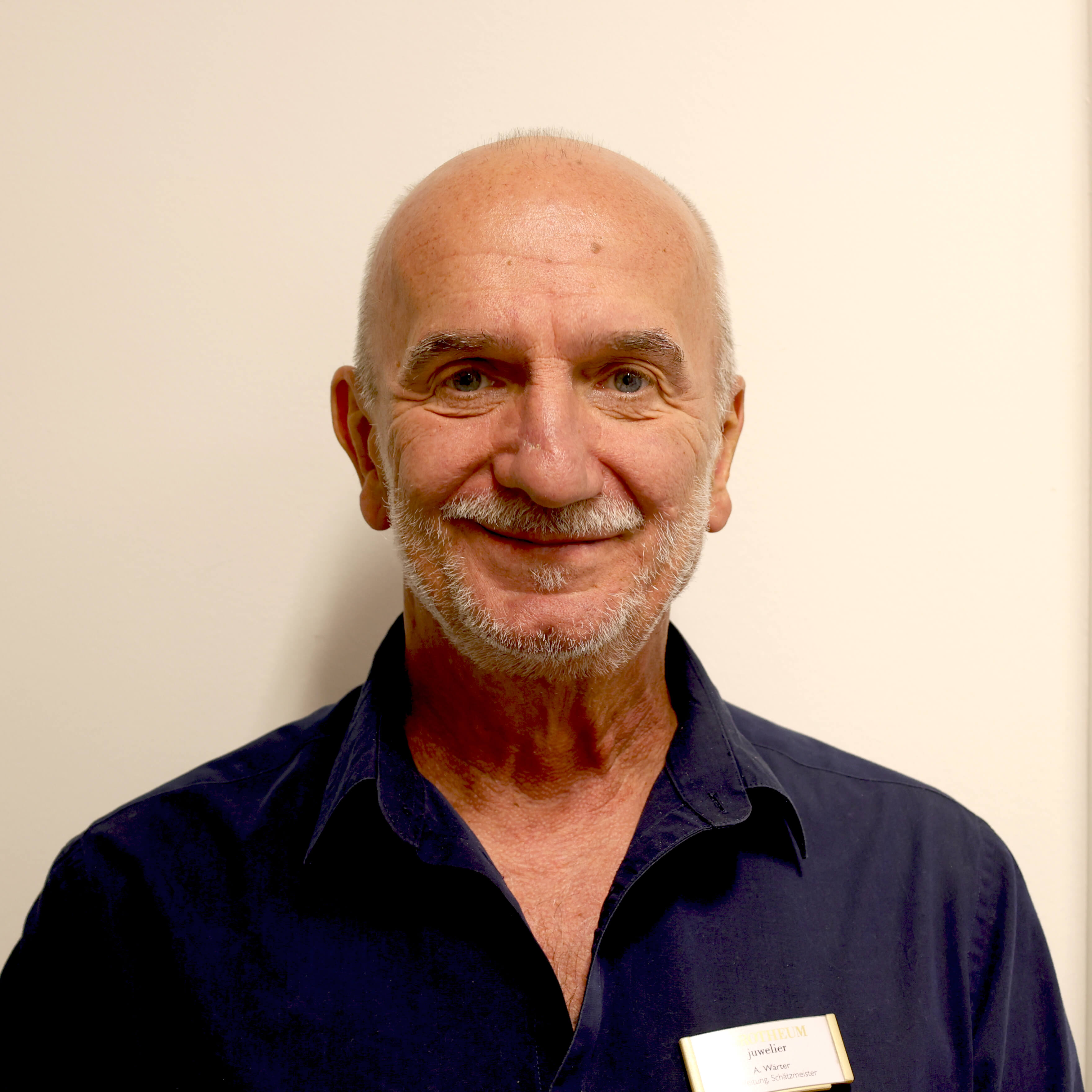 Alexander Wärter filialleiter-und-schaetzmeister-laechelnd-vor-einer-wand
