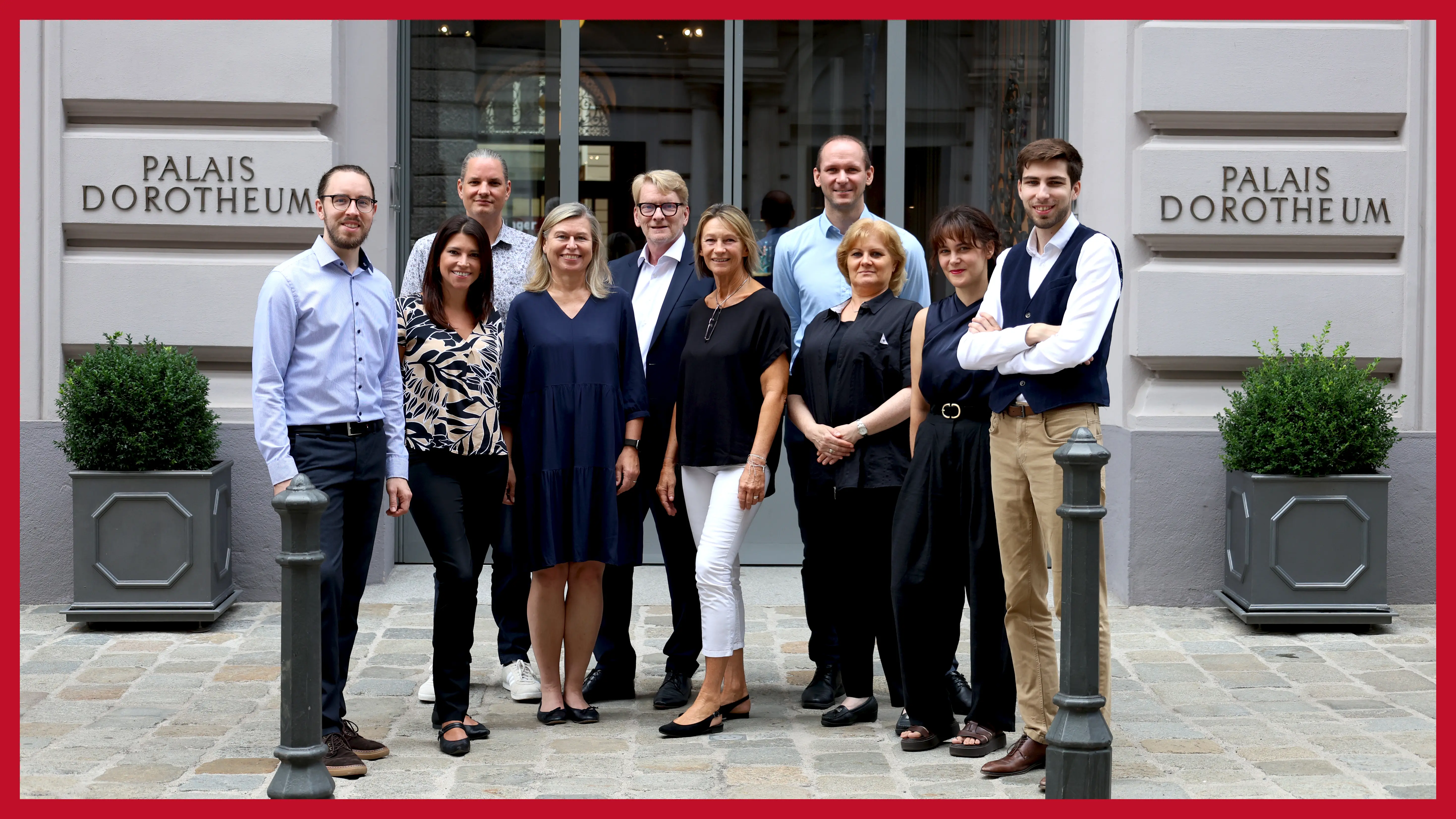 Das Team der Pfandleihe 1010 Wien neun-personen-stehen-vor-der-filiale-im-ersten-berzirk-an-einem-sonnigen-tag