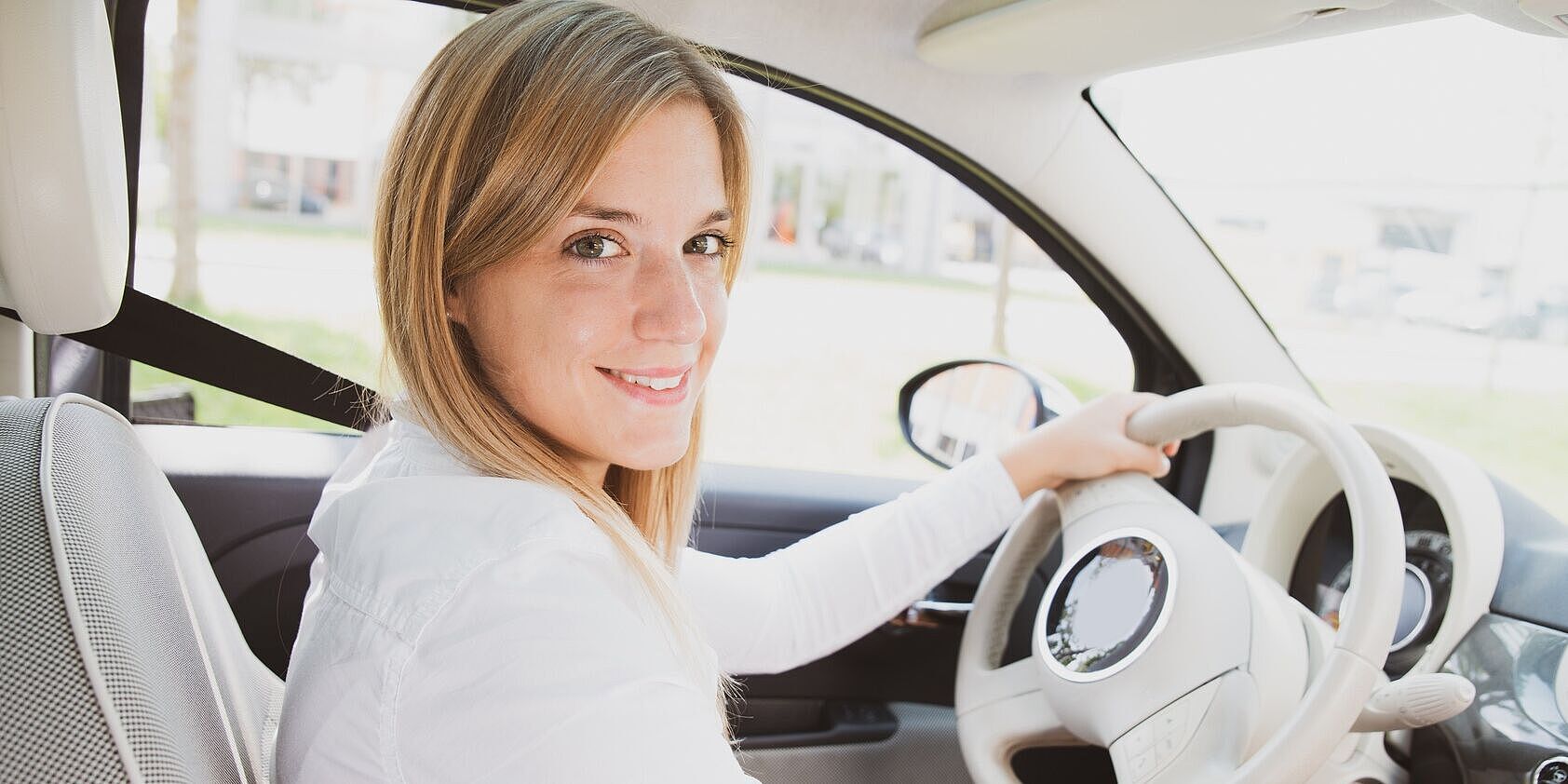 Junge Frau am Steuer ihres Autos