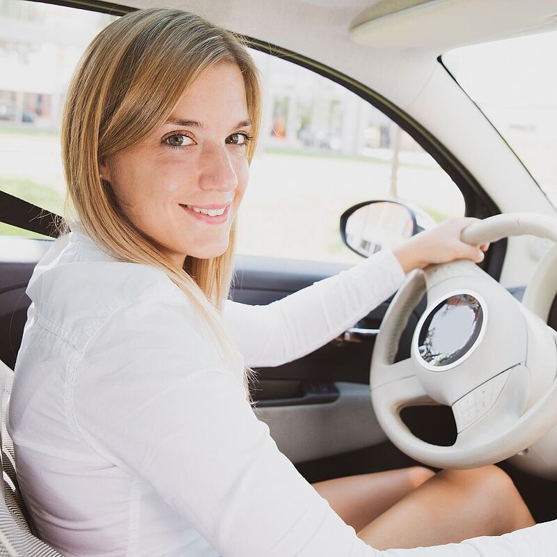 Junge Frau am Steuer ihres Autos