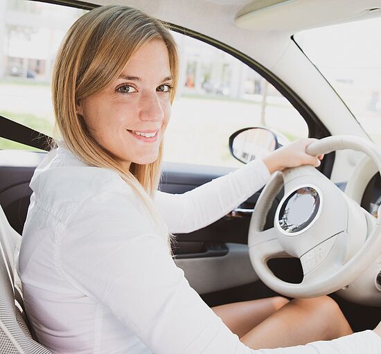 Junge Frau am Steuer ihres Autos