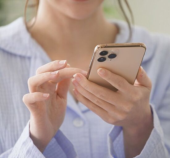 Frau bedient Smartphone für ein Technik Darlehen