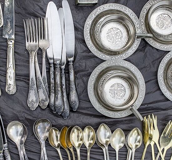 Verschiedene Bestecke aus Silber auf einem Flohmarkttisch - echt oder nur versilbert?