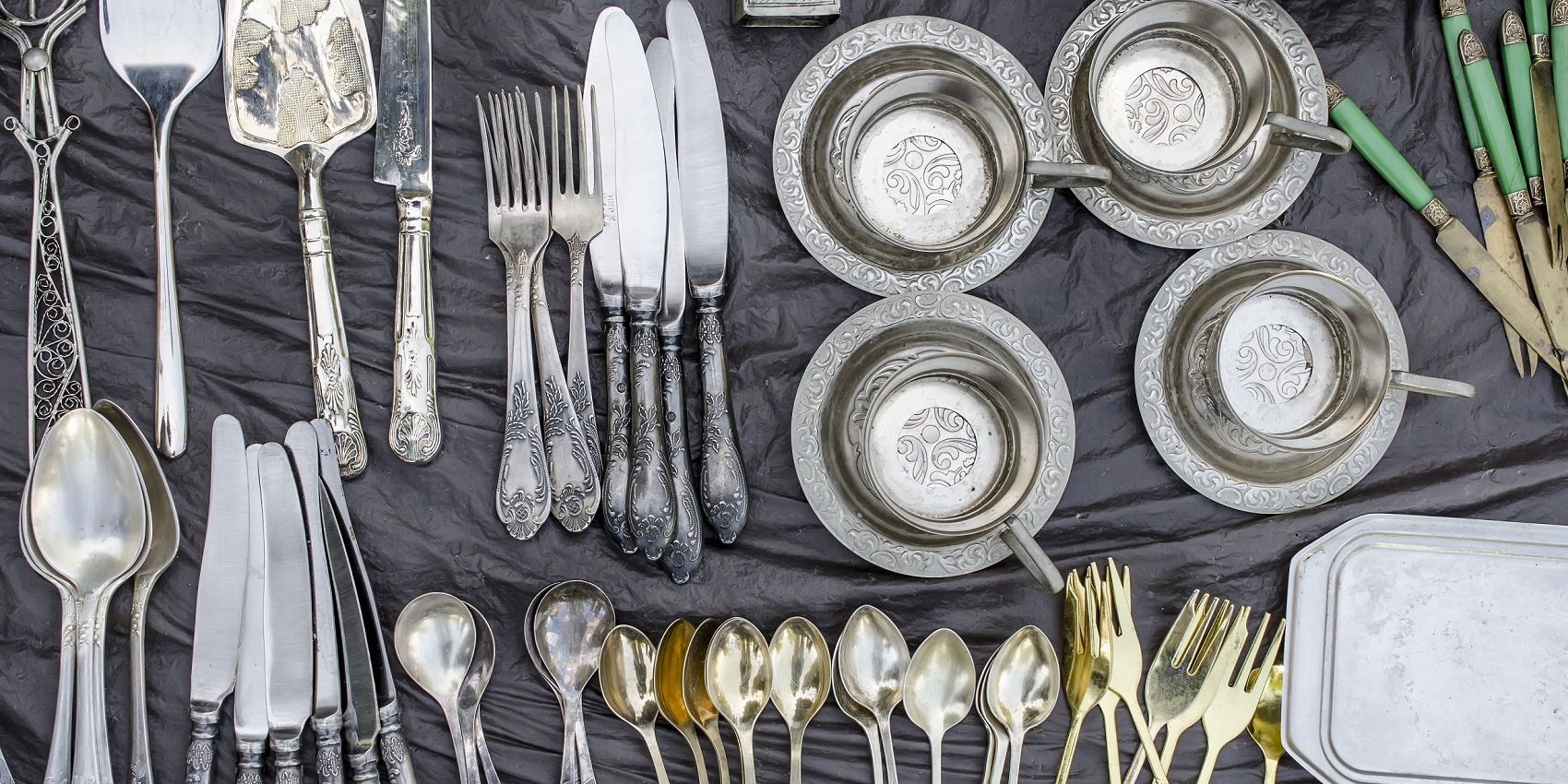 Verschiedene Bestecke aus Silber auf einem Flohmarkttisch - echt oder nur versilbert?